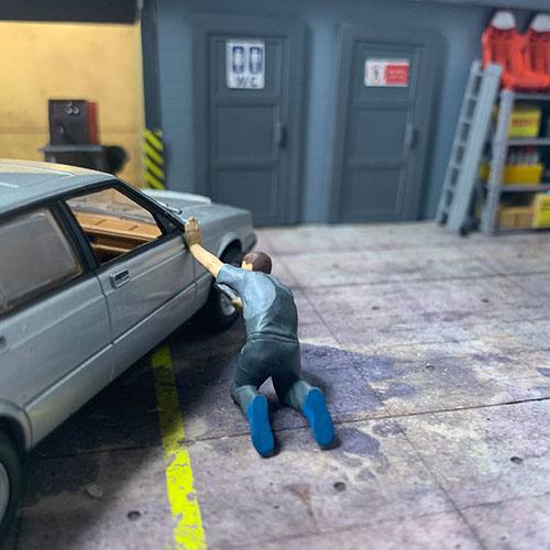 1-43 garage diorama figurine of a mechanic removing a wheels in a garage
